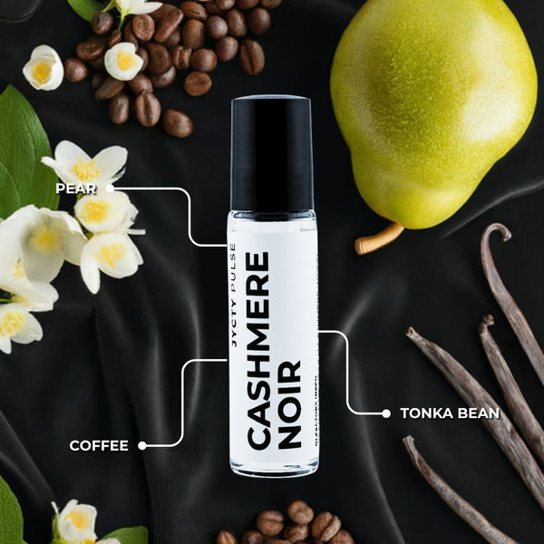 Cashmere Noir perfume bottle with pear, coffee beans, and vanilla on a black background