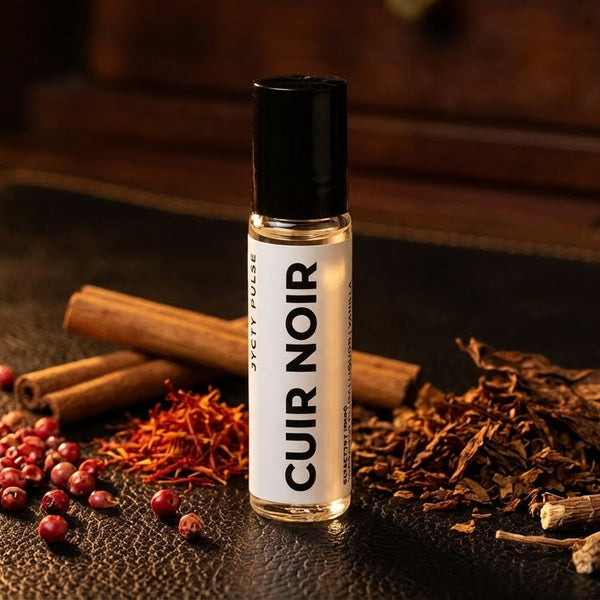 Roll-on bottle labeled 'Cuir Noir' with spices and herbs on a dark surface