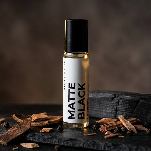 Roll-on bottle labeled 'Matte Black' on a dark surface with wooden pieces.